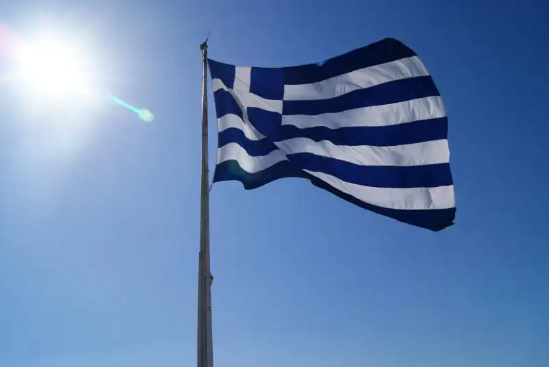 Drapeau grec flottant au vent avec ciel bleu – Décalage horaire Grèce