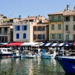 ue du port de Cassis avec ses barques colorées et les façades pastel du centre-ville