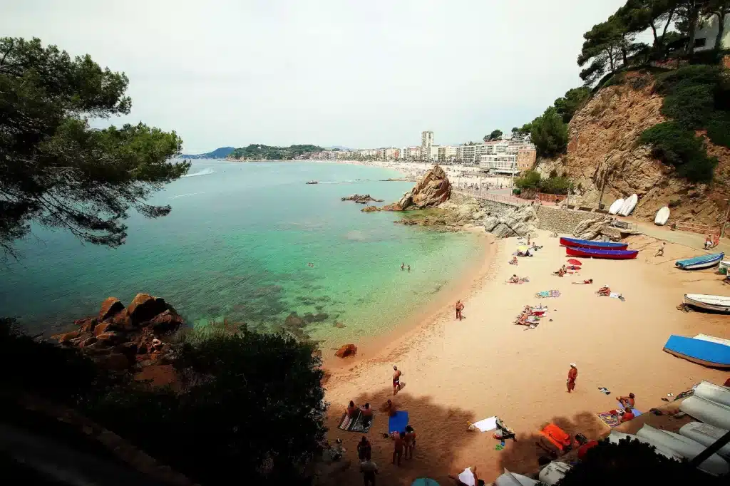 Petite plage de Sa Caleta avec la baie et le centre de Lloret de Mar en arrière-plan